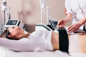 Woman getting ems treatment on stomach to burn fat, build muscles and remove cellulite. Woman Getting Body sculpting Evolve Body Remodeling Evolve Body Contouring Treatment | Melindas Med Spa & Salon in North Myrtle Beach, SC